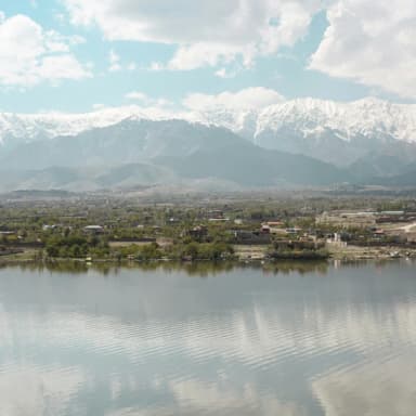 Snowy mountains reflected in Qargha Lake
